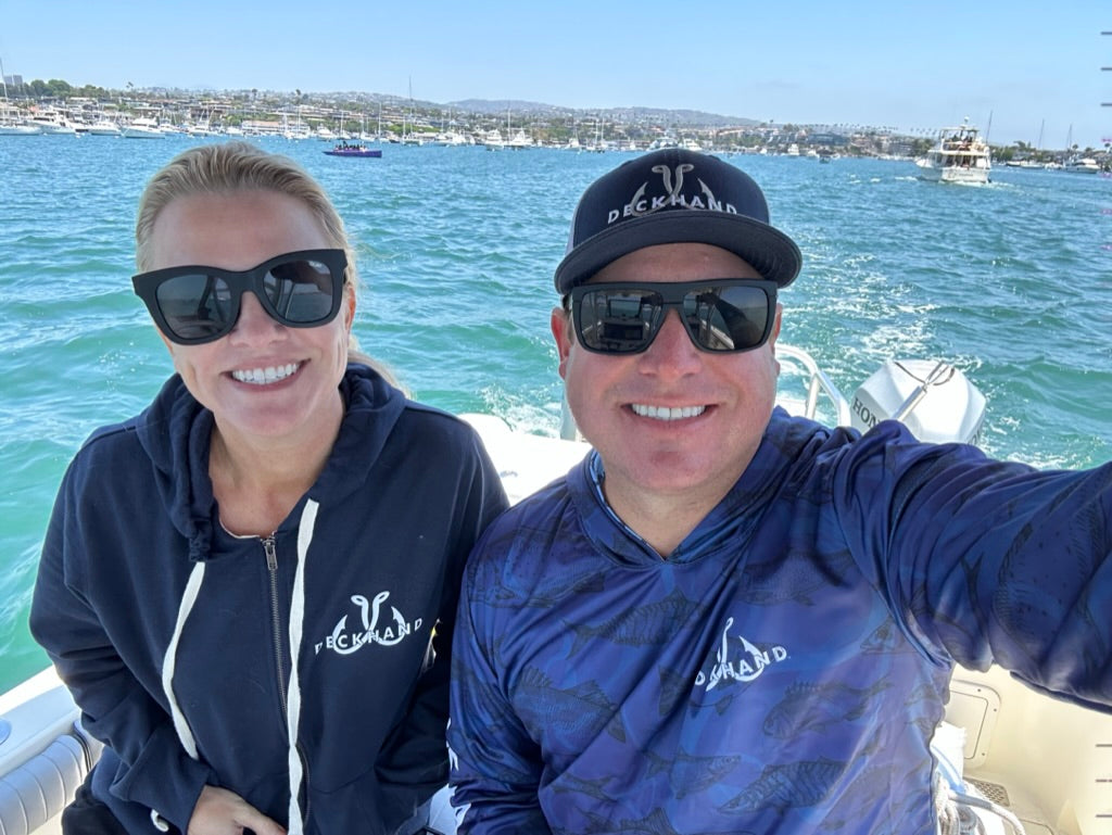 An adventurous woman angler on a fishing boat at sunrise, wearing a stylish zip-up hoodie, surrounded by high-quality fishing gear.