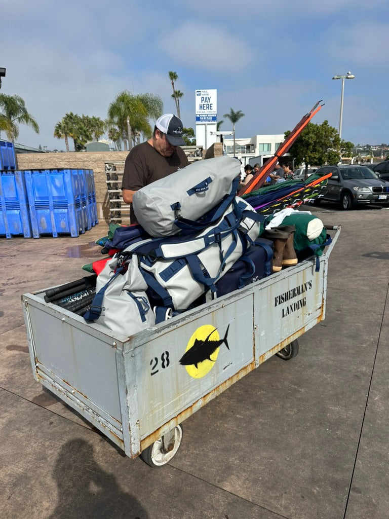 Fishing enthusiasts on a boat using Deckhand Sports products like Kill Bags, Dry Bags, and Coolers in a dynamic outdoor scene.